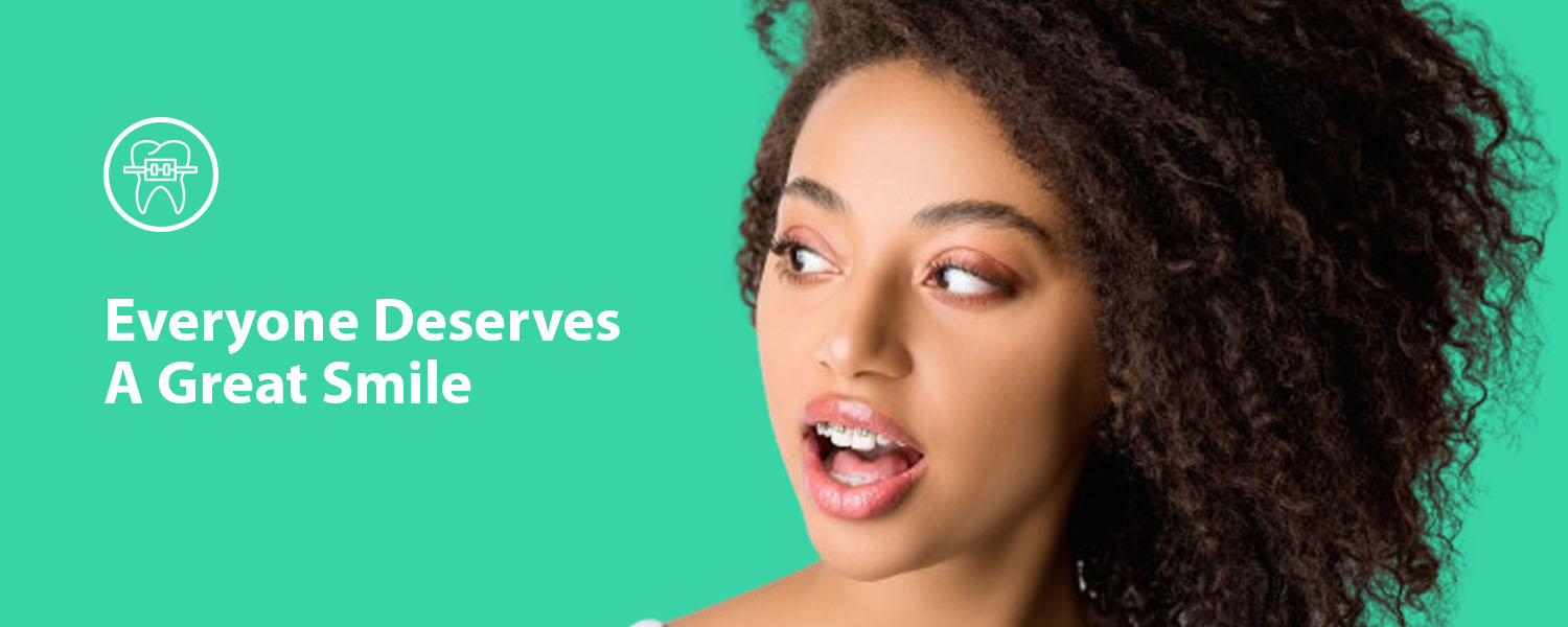 139375939 surprised african american woman with dental braces looking at toothbrush isolated on grey